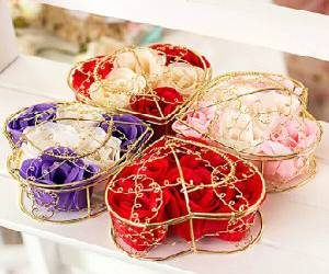 Gifts in boxes wrapped in red coloured and silver coloured wrappers and golden coloured bow tiep up over them.